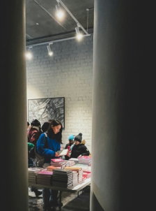People look at books displayed at a book signing.